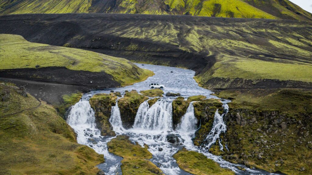 Wasserüberquerung der Mercedes-Benz G-Klasse in einer grünen Berglandschaft