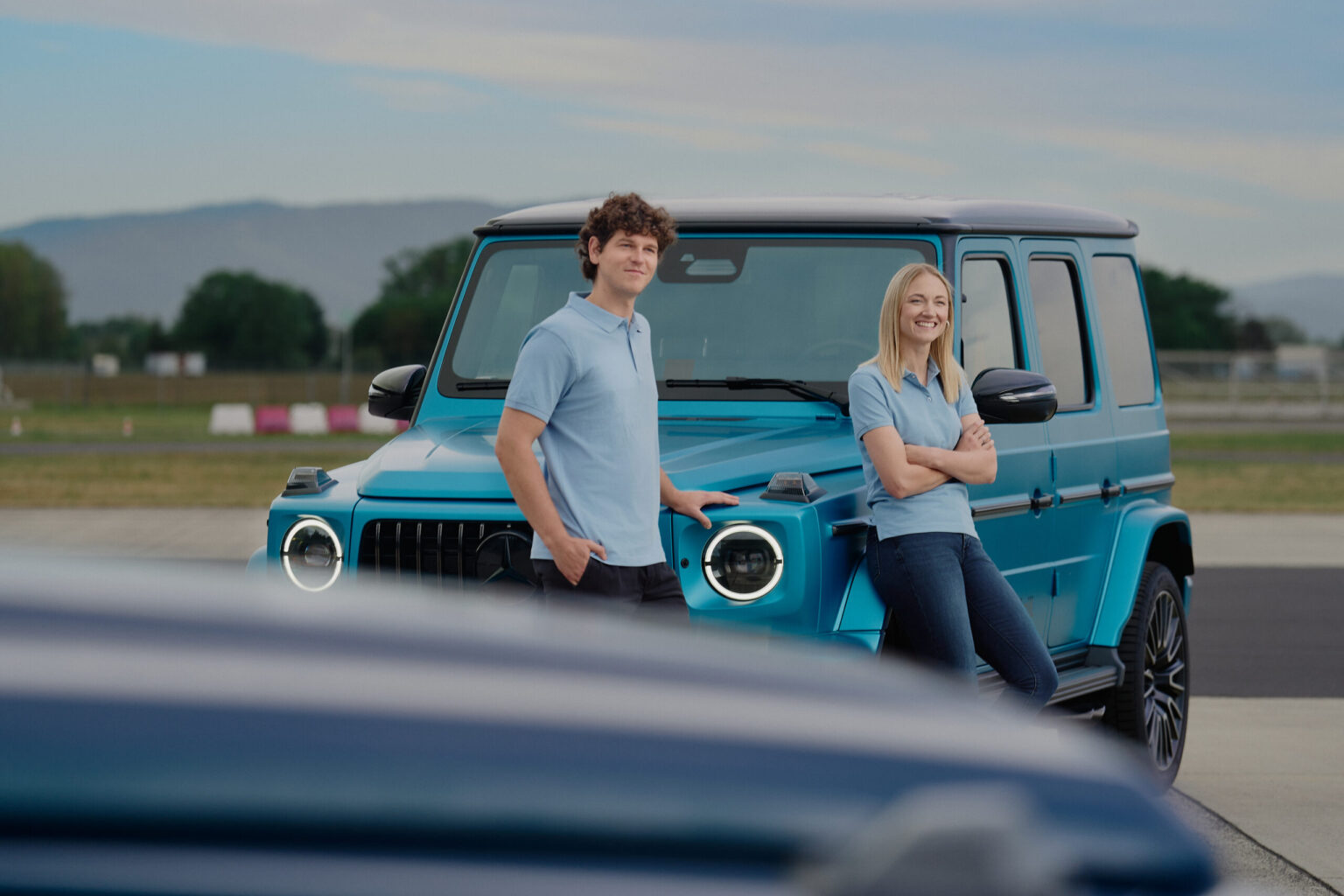 Personen stehen vor einer Mercedes-Benz G-Klasse auf dem Gelände des Experience Centers.